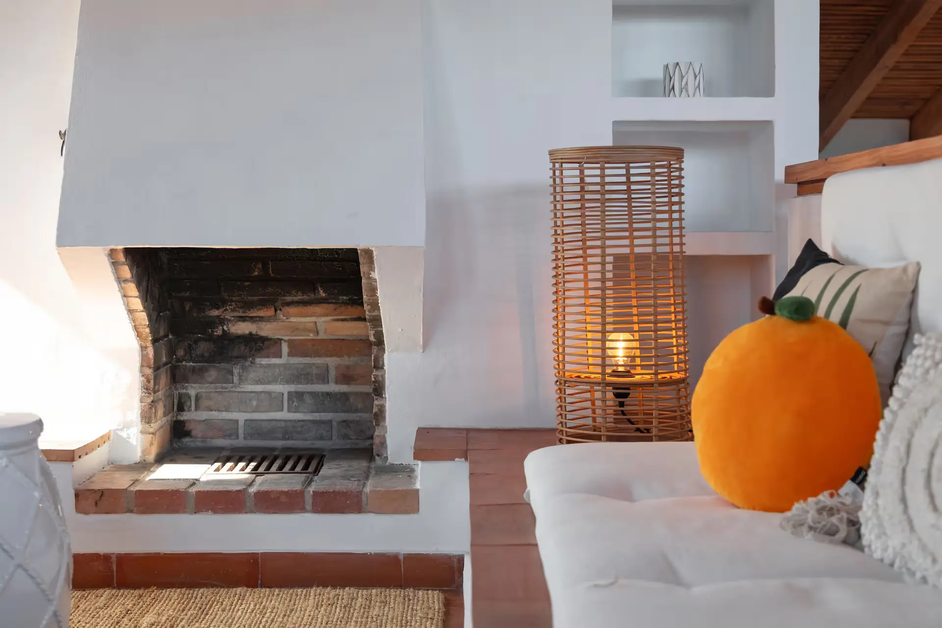 Open fireplace with an orange on the mantelpiece