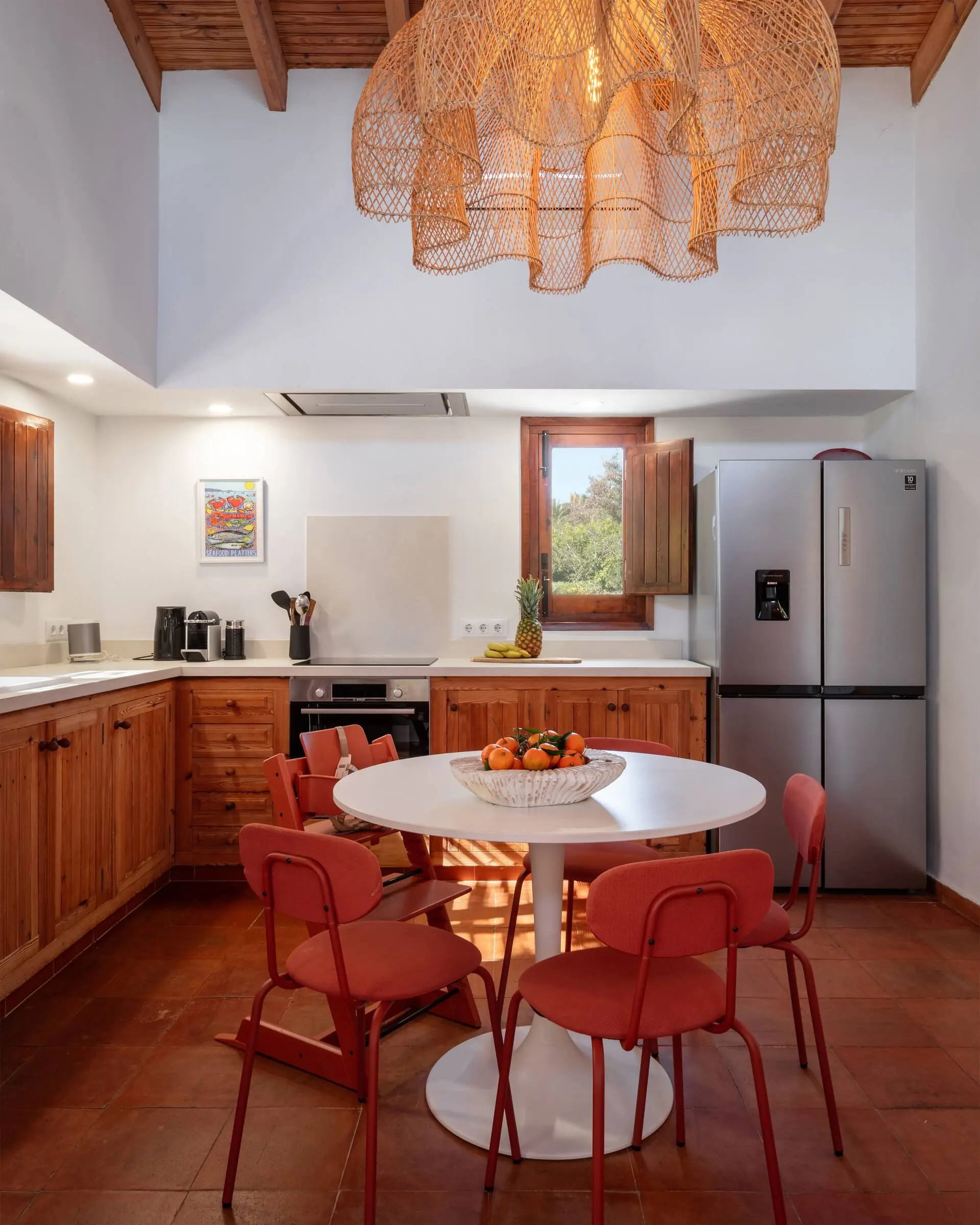 Fully equipped kitchen with a dining table and red chairs