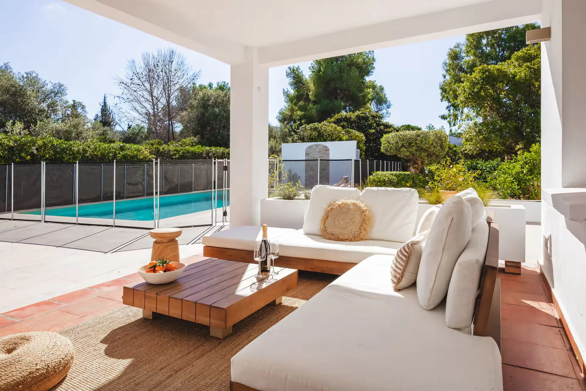 Covered terrace with a lounge sofa and a view of the pool