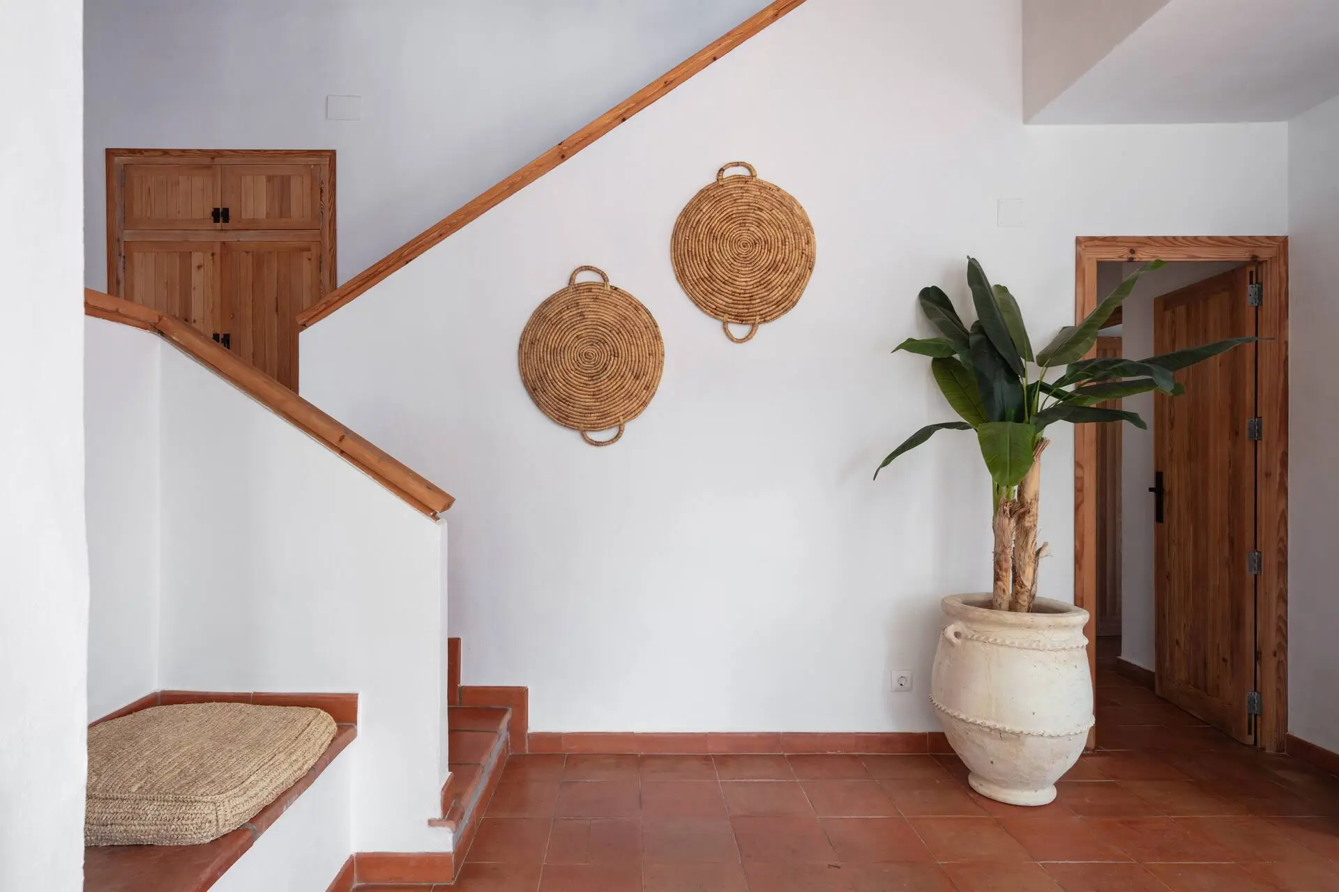 Terracotta staircase with rattan wall decoration