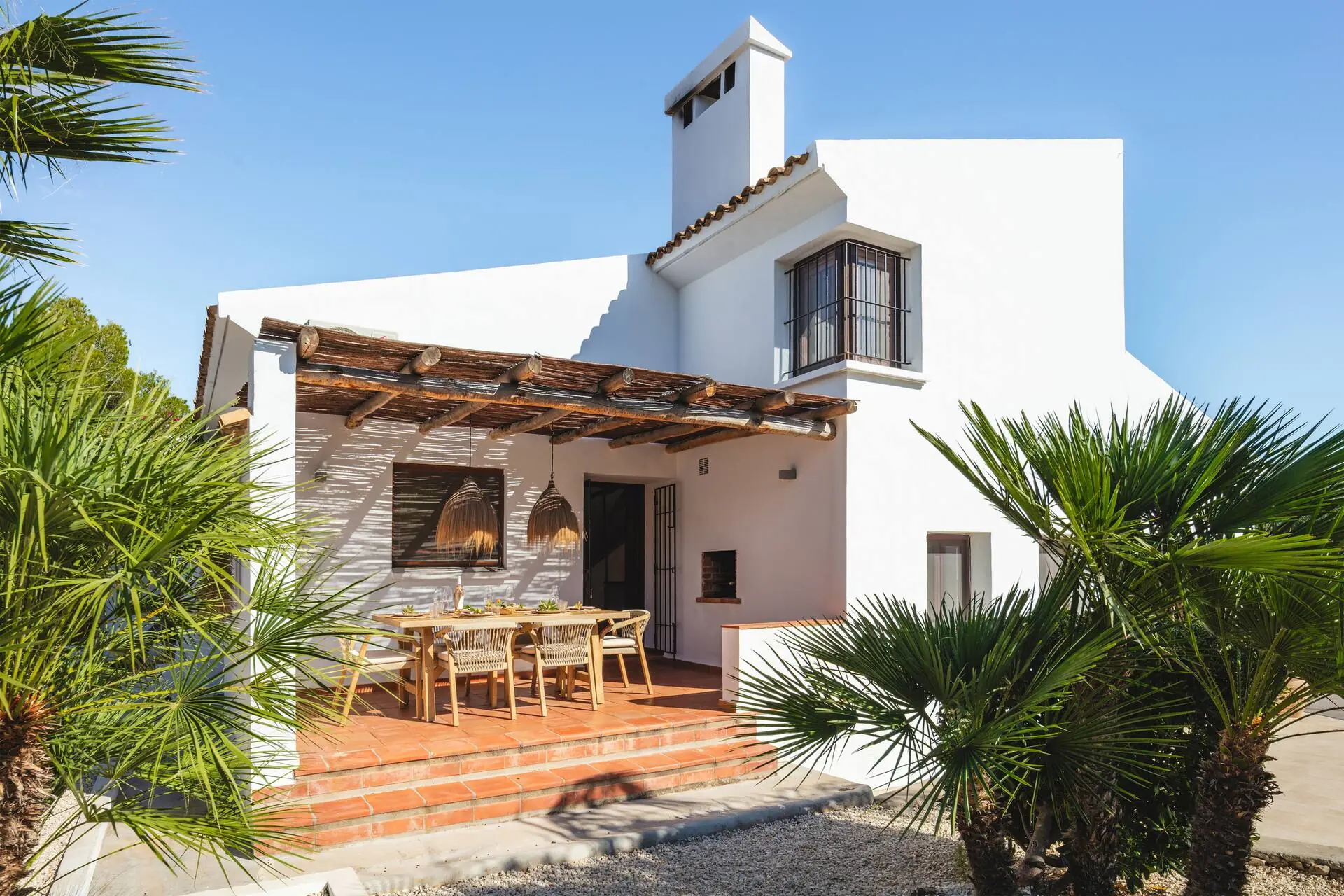 The villa with palm trees and the covered terrace